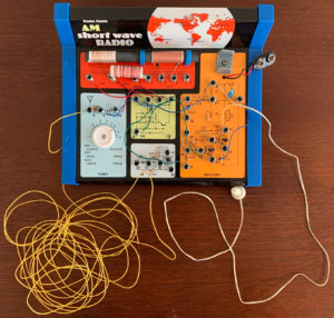 The radio kit with wire antenna (yellow) and ear piece (white).